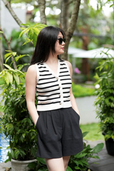 a lady in a  striped knit vest and a pair of black shorts